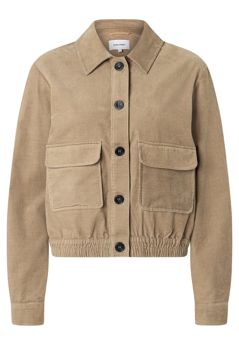 Tan corduroy jas met een kraag, elastische tailleband en twee voorkruistassen. Voorzien van zes zwarte knopen aan de voorkant.