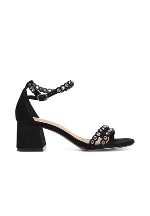 Sandal in suede nera con tacco a blocco e cinturino alla caviglia, adornato da accenti rotondi di strass sulle cinghie e sui lati.
