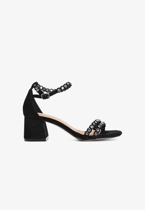 Sandal in suede nera con tacco a blocco e cinturino alla caviglia, adornato da accenti rotondi di strass sulle cinghie e sui lati.