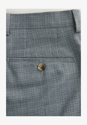 Maßgeschneiderte Hosen in einem strukturierten blau-braunen Muster, mit einer schräg angeordneten Gesäßtasche und einem runden, braunen Knopfdetails.