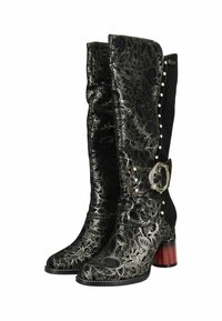 Des bottes montantes présentent une superposition de dentelle noire, des côtés en daim, des accents métalliques brillants et un talon bloc rayé rouge et noir. Détail de boucle décorative.