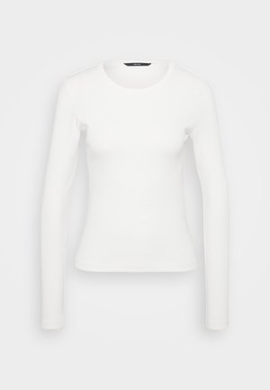 Bela dolga majica z ribanim vzorcem, ki ima okroglo ovratnico in oprijet kroj. Gladka tekstura s preprostim dizajnom, brez vzorcev ali dodatkov.