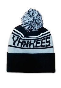 Gorro de punto en negro y azul claro, con un gran pompón en la parte superior y la palabra "Yankees" destacada en letras negras.