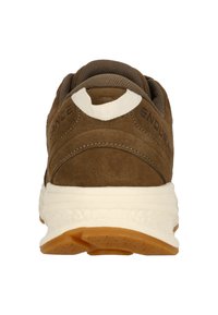 Baskets de sport en daim brun avec un col en tissu texturé et des accents blancs. Doté d'une semelle intermédiaire blanche épaisse et d'une semelle en caoutchouc brun.