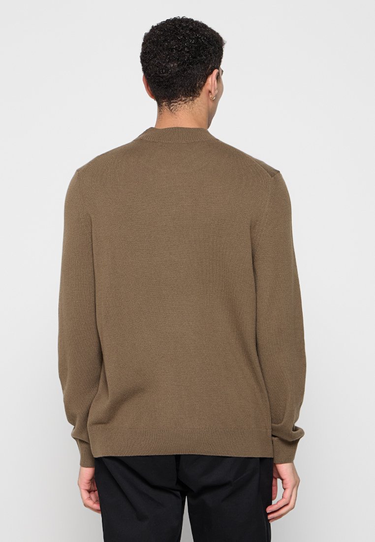 Brauner Strickpullover mit Rippstruktur, rundem Halsausschnitt und langen Ärmeln, von hinten gegen einen hellen Hintergrund gezeigt.