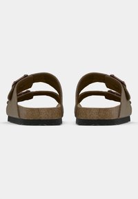 Sandales ouvertes marron avec deux baskets réglables, semelle en liège et semelle en caoutchouc noir, présentant une surface texturée pour une meilleure adhérence.