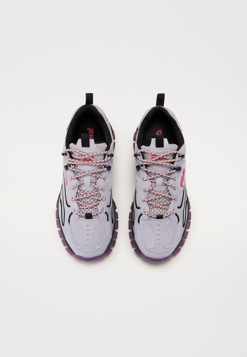 Scarpe da ginnastica di un delicato colore viola con tomaia in mesh, dettagli neri, suole testurizzate e lacci con motivo. Presentano due linguette per facilitare l'indossamento.