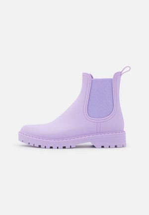 Botte de pluie Chelsea lilas avec panneaux latéraux élastiques, languette au talon et semelle texturée pour une bonne adhérence sur fond blanc.