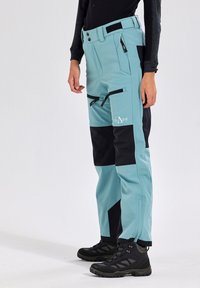 Cyan and black pants with a slim fit, featuring multiple zippered pockets, reinforced areas, and a smooth, durable fabric.