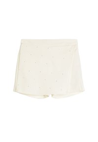 Pantalones cortos color crema con una tela texturizada y suave, que presentan pequeños puntos negros dispersos por la superficie y un diseño envolvente.