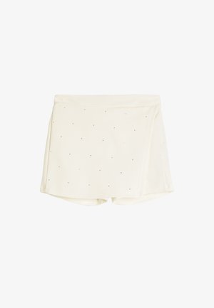 Shorts de couleur crème en tissu lisse et texturé, avec de petits points noirs éparpillés sur la surface et un design enveloppant.