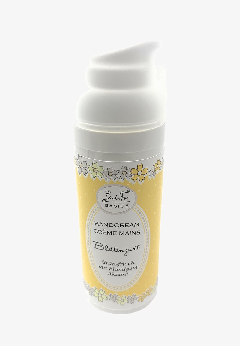 Yellow hand cream bottle with a white pump top. Features floral patterns and text in black, indicating the product type and fragrance.