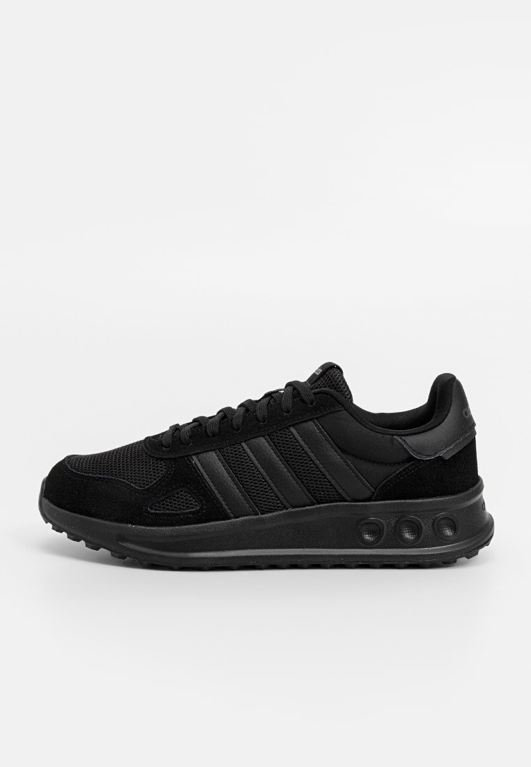 Scarpa sportiva nera con tomaia in mesh e suede, caratterizzata da tre strisce nere, ammortizzazione rotonda sulla suola e chiusura con lacci.