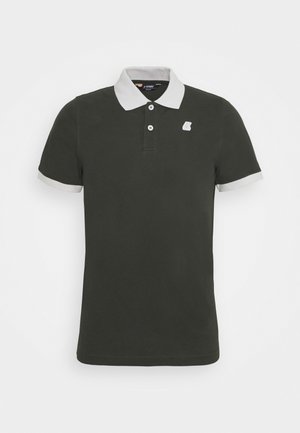 Polo vert foncé à manches courtes avec col blanc, poignets blancs, deux boutons blancs et petit logo blanc sur la poitrine.