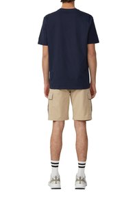 Navy katoenen t-shirt, korte mouwen, relaxte pasvorm; beige cargoshorts met zijzakken; wit en zwart gestreepte sokken; grijze sneakers.