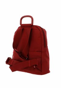 Sac à dos en tissu rouge avec une finition texturée, doté de bretelles réglables et d'une poignée supérieure, fermeture à glissière et poche latérale.