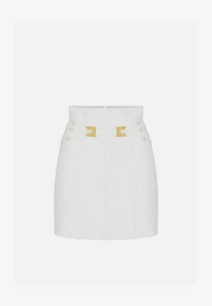 Mini gonna bianca a vita alta con due fibbie rettangolari dorate e cinturini laterali regolabili con piccoli bottoni dorati.