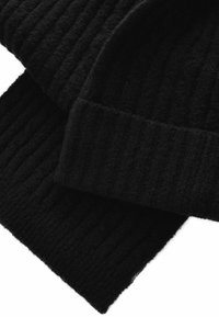 Svart ribbade stickade mössa och scarf-set. Tillverkad av mjukt, texturerat material med en slät yta, med en enhetlig svart färg och subtilt mönster.