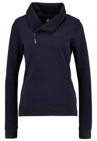 Marinblå hoodie med hög krage, sned dragkedjestängning och strukturerade muddar. Har två svarta runda knappar på sidan.