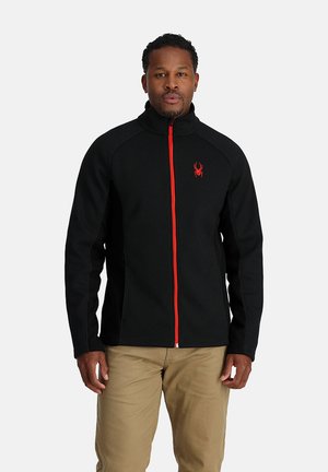 Zwarte fleece jas met een hoge kraag en een ritssluiting aan de voorkant, voorzien van rode accenten en een spinlogo op de linkerborst.