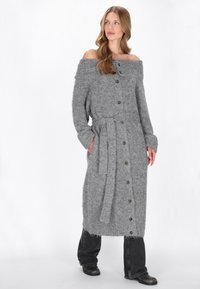 Cardigan lung de culoare gri, cu umerii descoperiți, realizat dintr-un material tricotat texturat, cu o curea în talie, având nasturi mari și buzunare laterale.