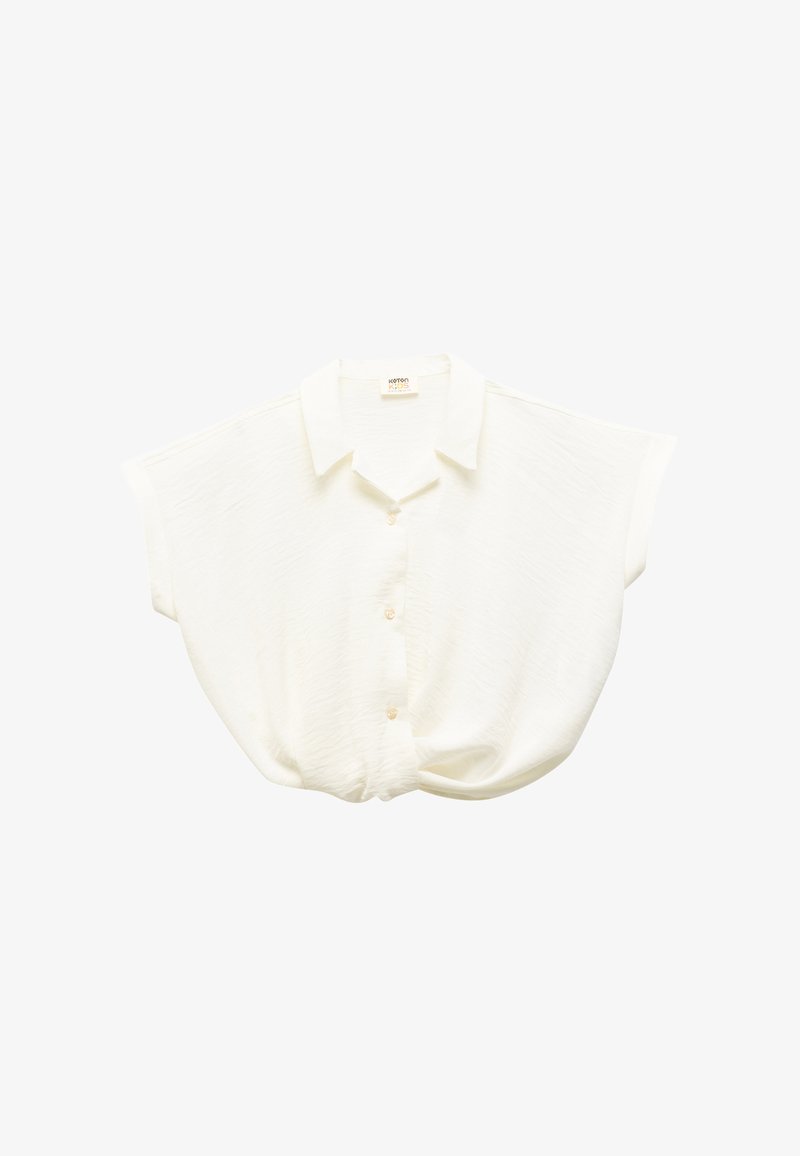 Short-sleeve, white button-up blouse with a textured fabric, featuring a collar and a gathered detail at the waist.