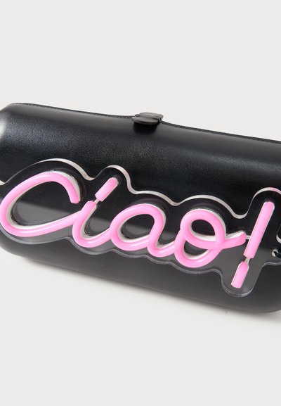 Μαύρο ορθογώνιο τσάντα-φάκελος με ροζ νέον επιγραφή «ciao!» προσδεδεμένη μπροστά.