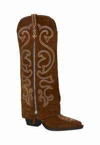 Botte de cowboy en daim brun avec des motifs de coutures blanches complexes, un bout pointu et une fermeture éclair arrière. Dotée d'un talon bas empilé.