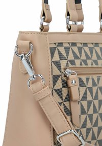 Beige handtas met een driehoekpatroon in zwart en roomkleur. Voorzien van zilverkleurige hardware, een ritszak en dubbele handvaten met een schouderriem.