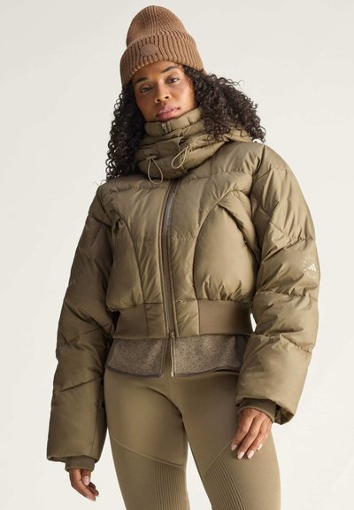 Olivengrüne Pufferjacke mit hohem Kragen und Reißverschluss, mit gesteppter Textur und geripptem Saum. Kombiniert mit passenden Leggings.
