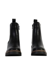 Bottines en cuir noir avec une finition lisse, des fermetures éclair sur les côtés et une semelle contrastante beige brodée. Talon plat avec semelle texturée.