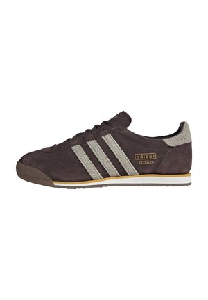 Sneaker Adidas Italia marrone scuro con strisce grigio chiaro, dettagli in pelle scamosciata e suola bianca e gialla, mostrata di lato su sfondo bianco.