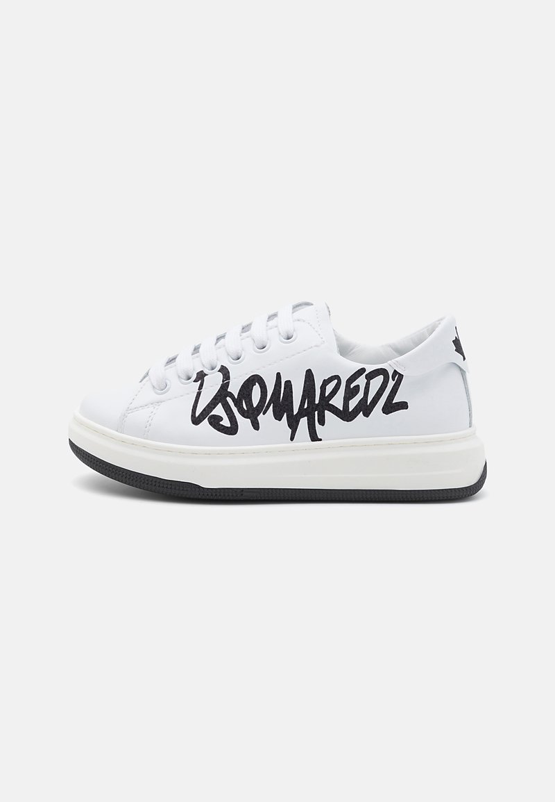 White leather sneakers with black graffiti-style logo on the side, round toe, flat rubber sole, and lace-up closure.