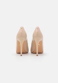 Nahé lakované lodičky s špicatými špičkami a štíhlými opätkami stiletto. Na zadnej strane majú malý zlatý detail.