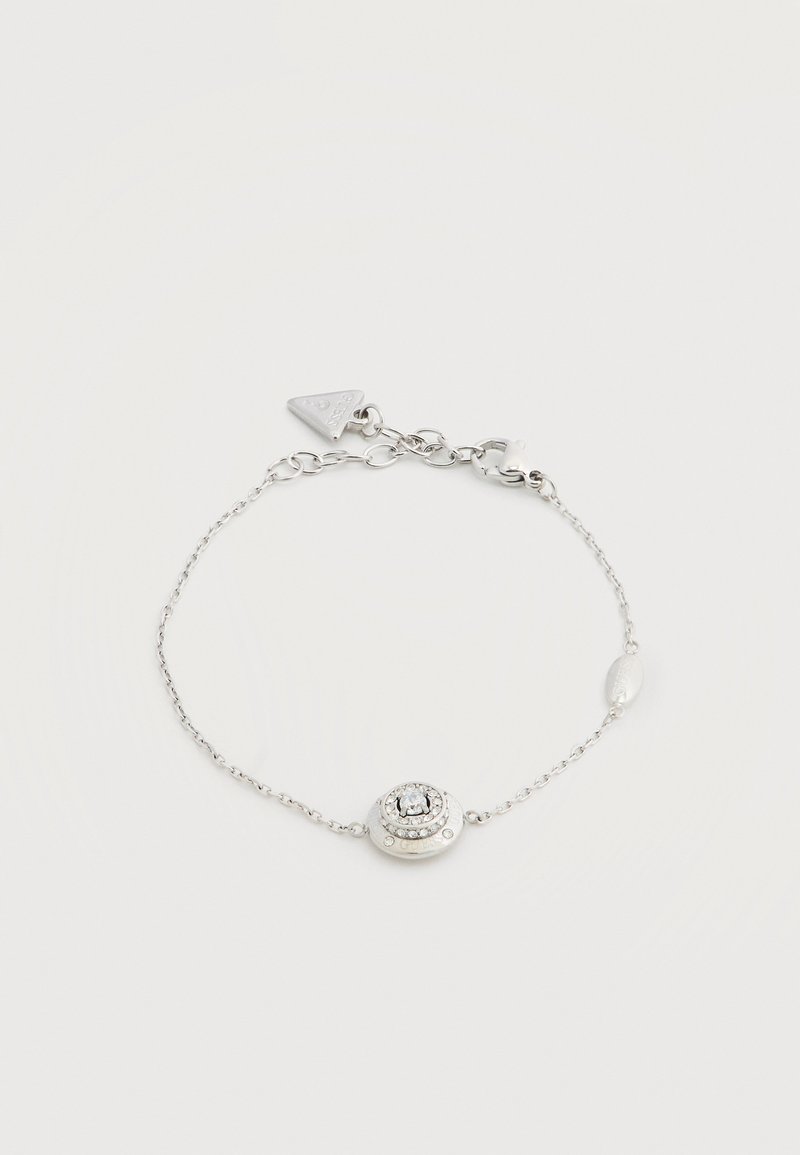 Ασημένιο βραχιόλι αλυσίδας με κυκλικό κεντρικό κομμάτι διακοσμημένο με μικρούς διαυγείς κρυστάλλους και ρυθμιζόμενο κούμπωμα με τριγωνική ετικέτα.