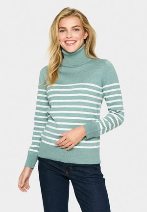 Lichtgroene coltrui met witte horizontale strepen. Geribbelde cuffs en onderrand, gemaakt van zacht breiwerk. G gedragen met donkere spijkerbroek.