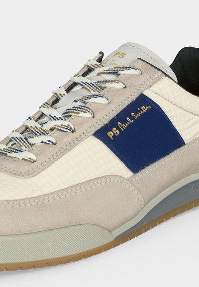 Αθλητικό παπούτσι σε μπεζ και λευκό με μπλε πάνελ, κορδόνια με σχέδιο, χρυσό λογότυπο "PS Paul Smith" και υφή στη σόλα.
