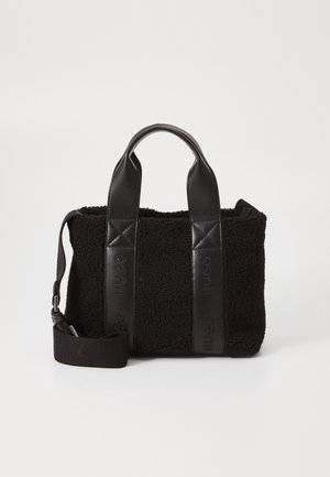 Zwarte getextureerde tote bag met leren handvatten en verstelbare schouderriem, met geperst "HUGO"-logo op leren panelen.