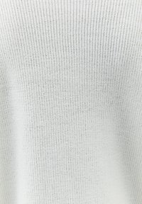 Jasnoszara, dziergana sweter z prążkowaną teksturą, charakteryzujący się miękkim, nieco puszystym wykończeniem oraz luźnym, swobodnym krojem.