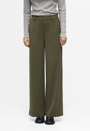 Olive green wide-leg trousers with a smooth texture, pleat front, belt loops, and side pockets, paired with black footwear.