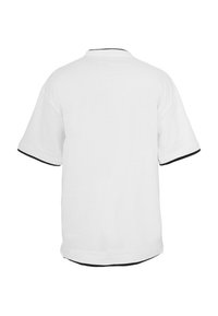 Fehér rövid ujjú ing fekete szegéllyel a galléron, az ujjmandzsettán és az alján, háttal fehér háttér előtt.