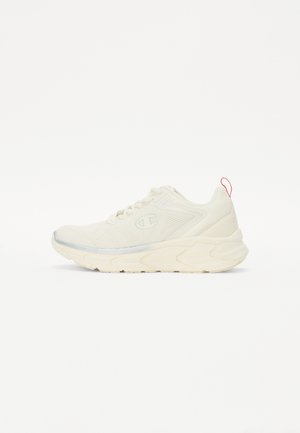 Sportowy but w kolorze ecru z grubą podeszwą, siateczkową boczną częścią, sznurówkami i czerwoną pętelką na pięcie.