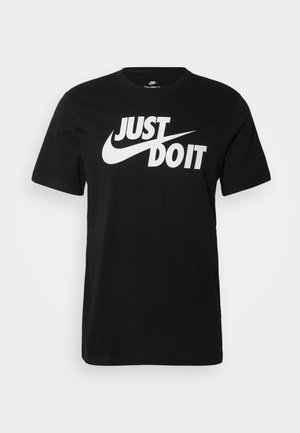 Must musta T-särk, millel on valge "Just Do It" tekst ja swooshi logo, lühikesed varrukad, ümardatud kaelus ja vabalt langev lõige.