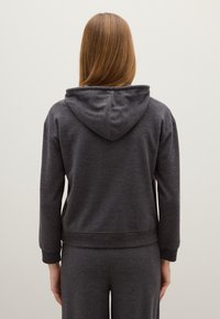 Felpa grigia scura realizzata in tessuto morbido, con cappuccio e polsini a costine, dal fit rilassato, vista dal retro.