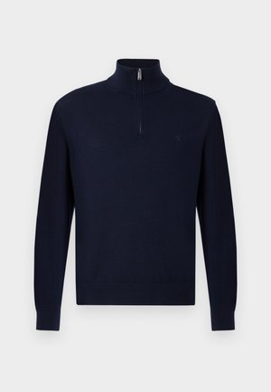Tumesinine pika varrukaga sviiter, millel on veerandzip kollektsioon ja diskreetne logo vasakul rinnal, esitletud lihtsal taustal.