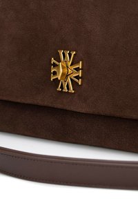 Czarna torebka z zamszu w kolorze ciemnego brązu, z klasycznym zapięciem w kolorze złotym i szerokim skórzanym paskiem. Gładka faktura z wyraźnym logo z przodu.