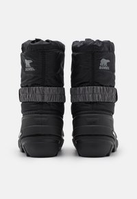 Botas de invierno aisladas negras con parte superior de nailon y banda elástica, que cuentan con suelas de goma y un sutil logo de un oso en la parte trasera.