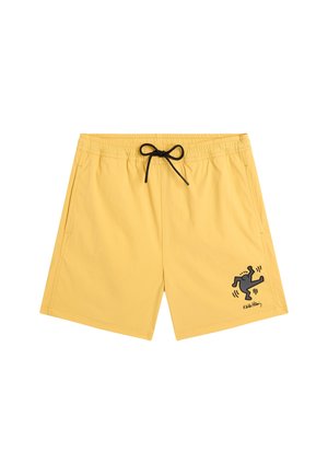 Gelbe Badeshorts mit elastischem Bund, schwarzem Kordelzug, Seitentaschen und einer kleinen schwarzen Grafik einer tanzenden Figur am linken Bein.