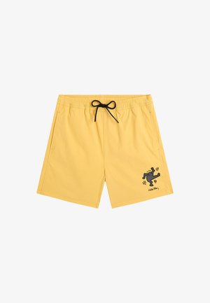 Shorts de bain jaunes avec une ceinture élastique, un cordon noir, des poches latérales, et un petit motif noir représentant une silhouette dansante sur la jambe gauche.