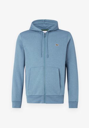 Himmelblaues Zip-Up Hoodie aus weichem Material. Verfügt über eine verstellbare Kapuze, Fronttaschen und ein Markenlogo auf der Brust.